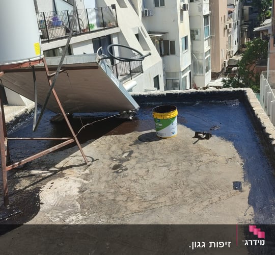 גג עם חומר איטום, דלי וכלי עבודה